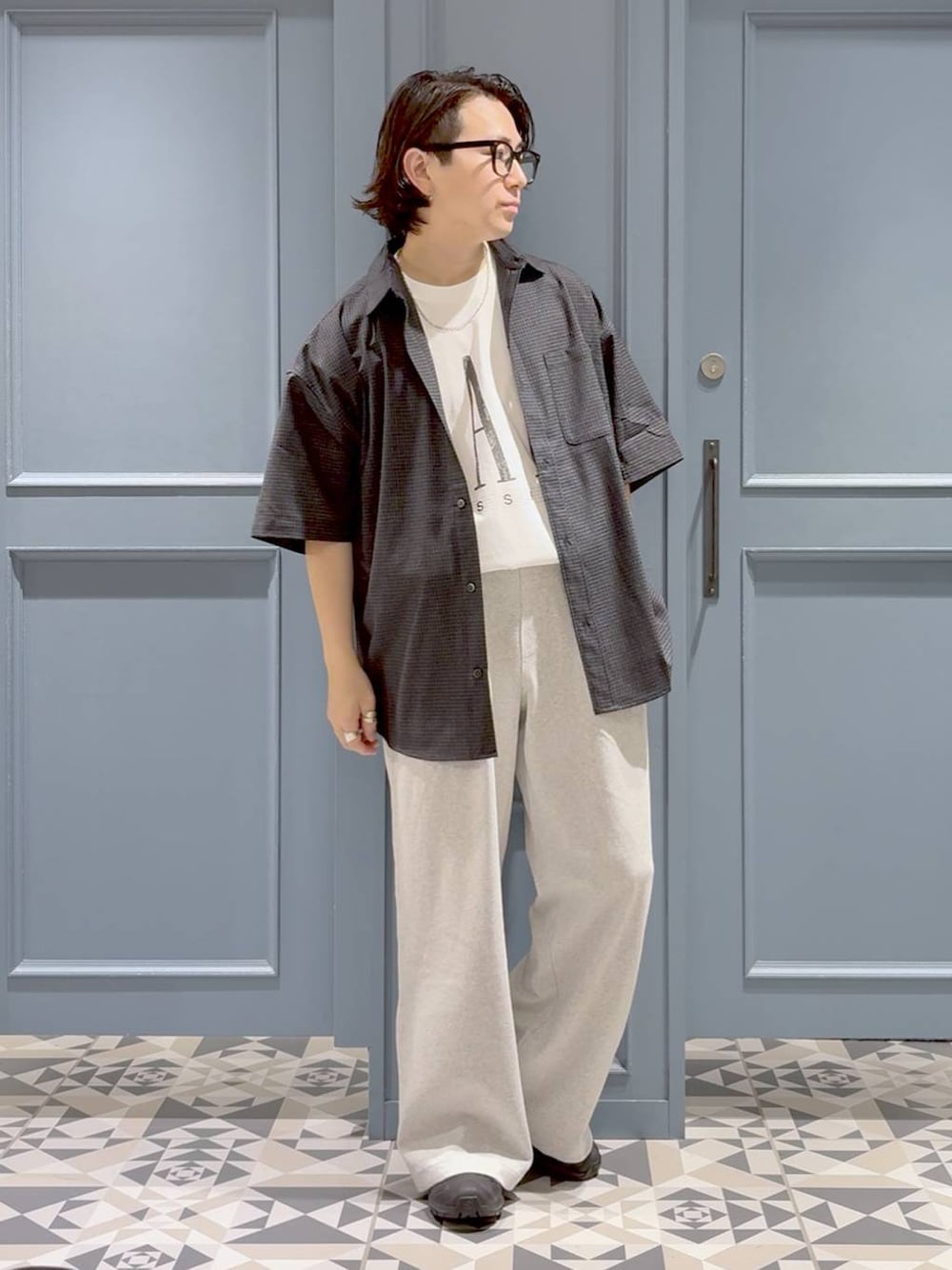 ブラック系のスニーカー、ホワイト系のTシャツ/カットソー、ブラック系のシャツ/ブラウスを着用したメンズの夏コーディネートの1枚目の写真