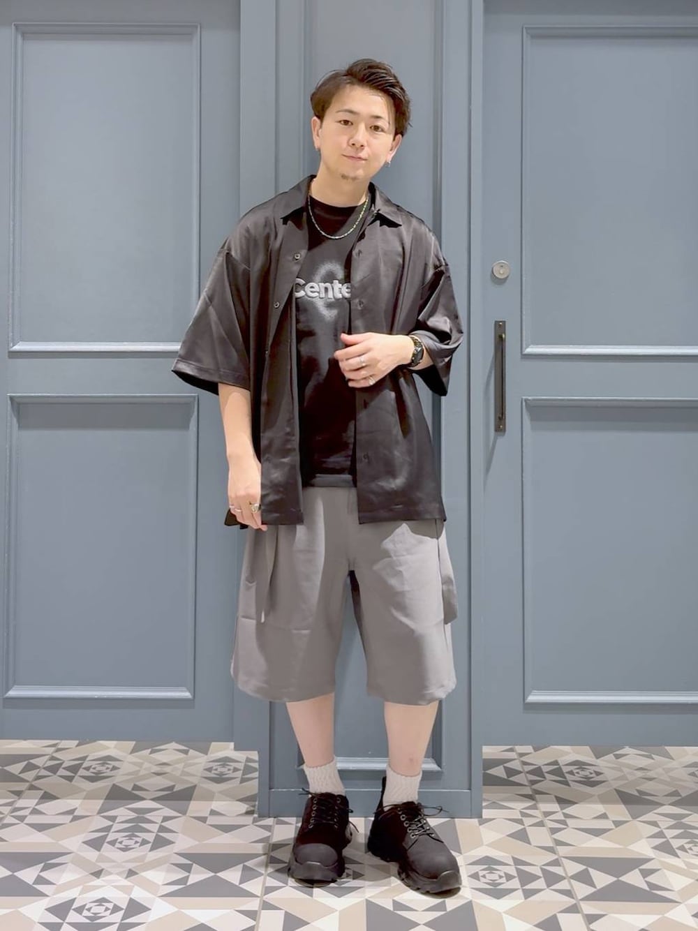 ブラック系のTシャツ/カットソー、ブラック系のシャツ/ブラウス、グレー系のスラックスを着用したメンズの夏コーディネートの1枚目の写真