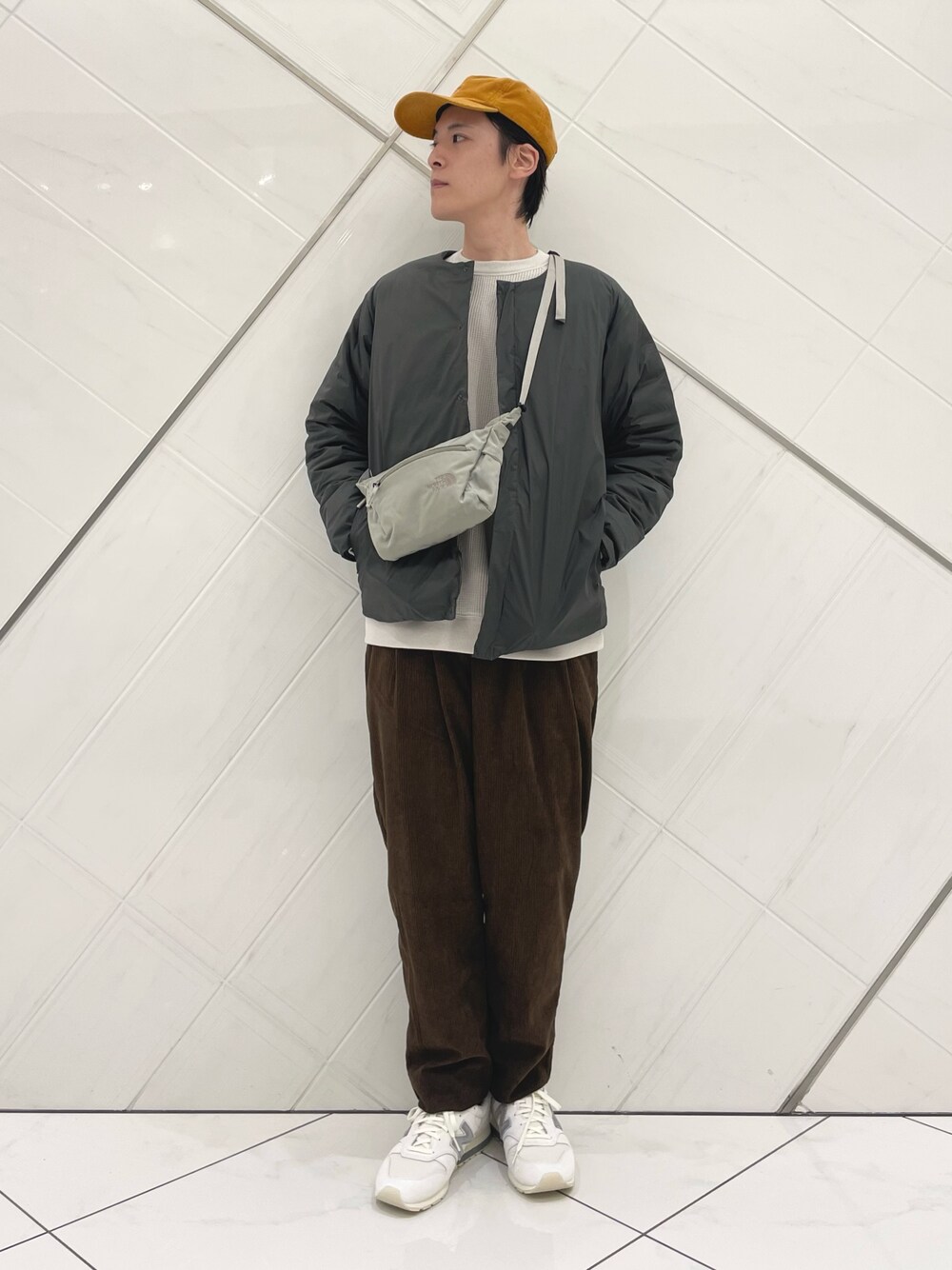 ブラウン系のダウンジャケット/コート、ベージュ系のTシャツ/カットソー、ブラウン系のその他パンツを着用したメンズの秋コーディネートの1枚目の写真