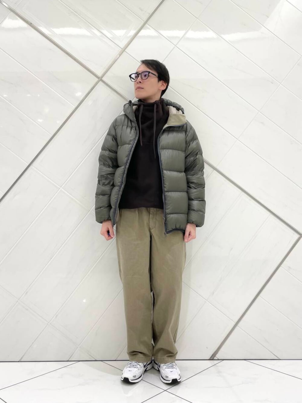 ホワイト系のスニーカー、ベージュ系のその他パンツ、グリーン系のダウンジャケット/コートを着用したメンズの冬コーディネートの1枚目の写真