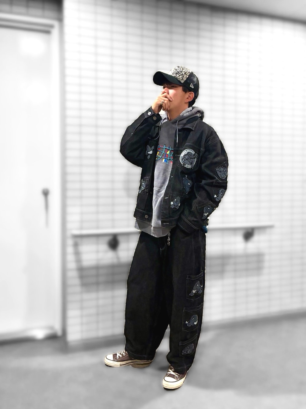 グレー系のパーカー、ブラック系のデニムジャケット、ブラック系のデニムパンツを着用したメンズの秋コーディネートの1枚目の写真