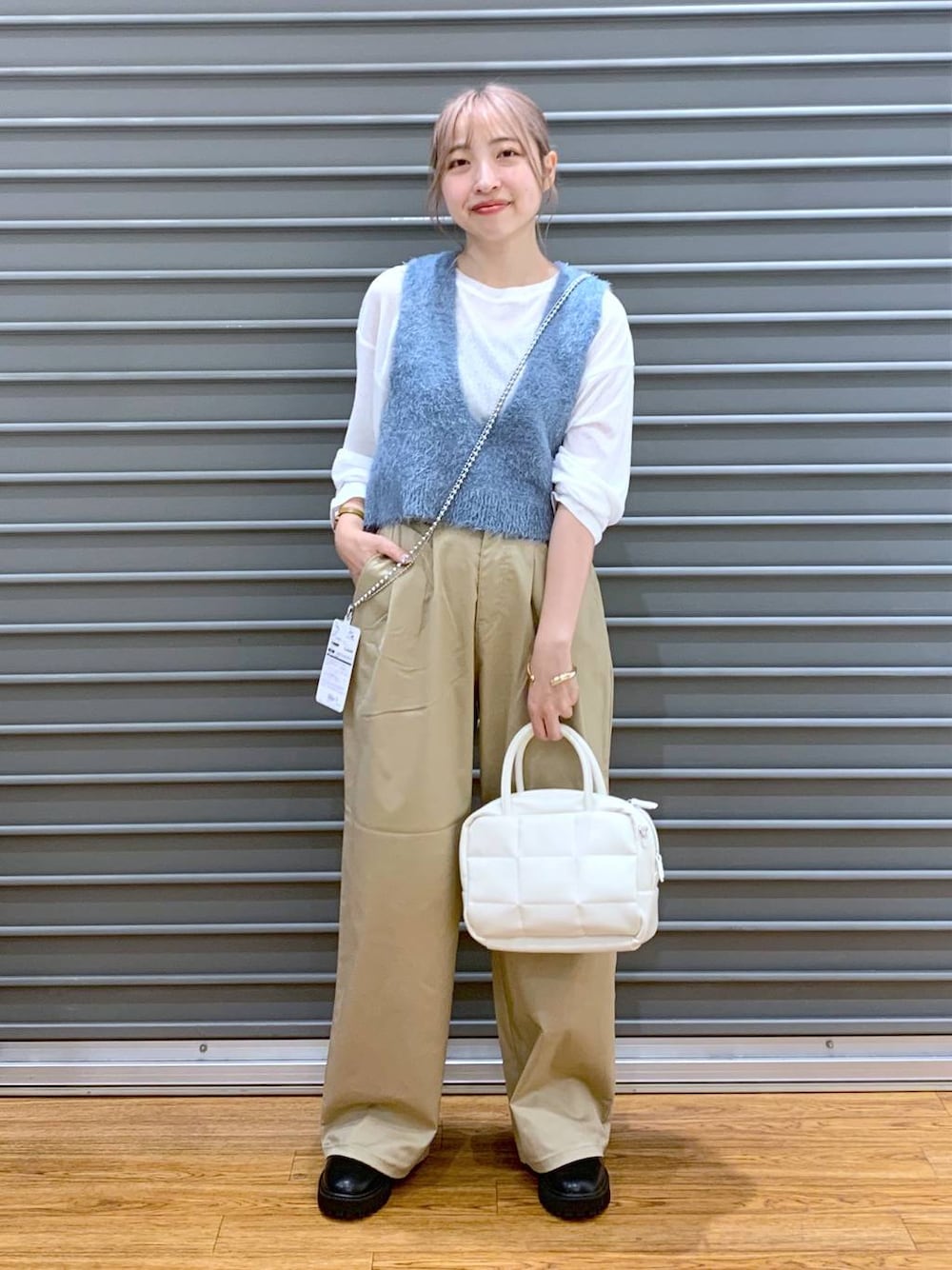 ホワイト系のTシャツ/カットソー、ブラック系のブーツ、ブルー系のベストを着用したレディースの秋コーディネートの1枚目の写真