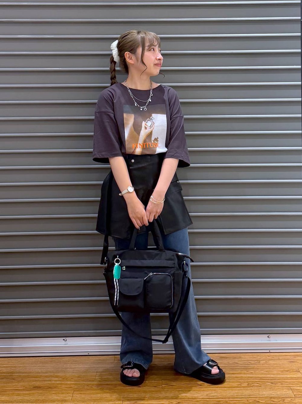 ブラック系のトートバッグ、ブラック系のサンダル、ブルー系のデニムパンツを着用したレディースの夏コーディネートの1枚目の写真
