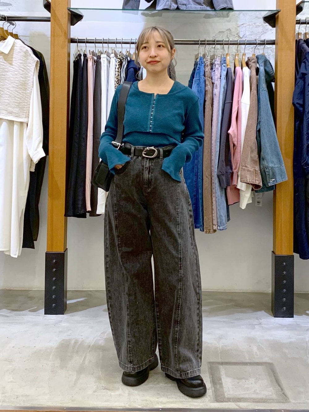 グリーン系のTシャツ/カットソー、ブラック系のデニムパンツ、ブラック系のショルダーバッグを着用したレディースの春コーディネートの1枚目の写真