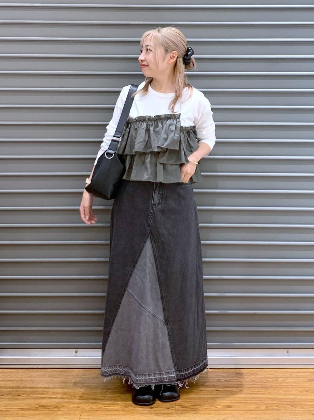 ブラック系のデニムスカート、グリーン系のTシャツ/カットソー、ブラック系のショルダーバッグを着用したレディースの秋コーディネートの1枚目の写真