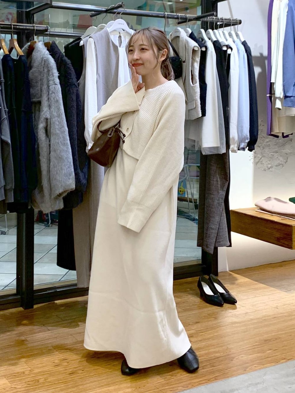 ブラック系のブーツ、ホワイト系のワンピース、ブラウン系のショルダーバッグを着用したレディースの冬コーディネートの1枚目の写真