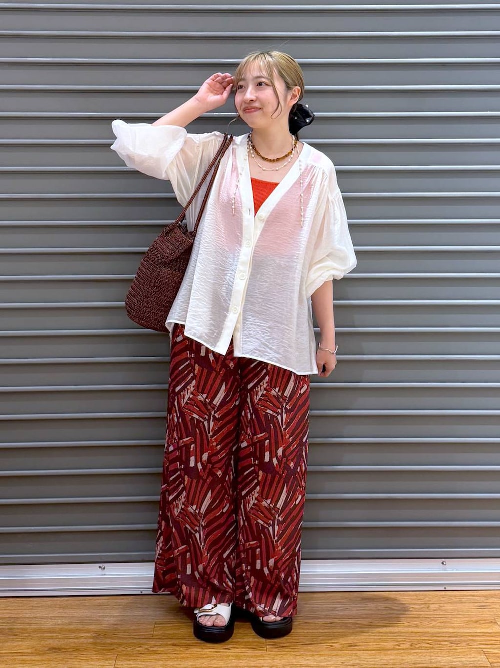 レッド系のその他パンツ、ホワイト系のサンダル、ベージュ系のシャツ/ブラウスを着用したレディースの夏コーディネートの1枚目の写真