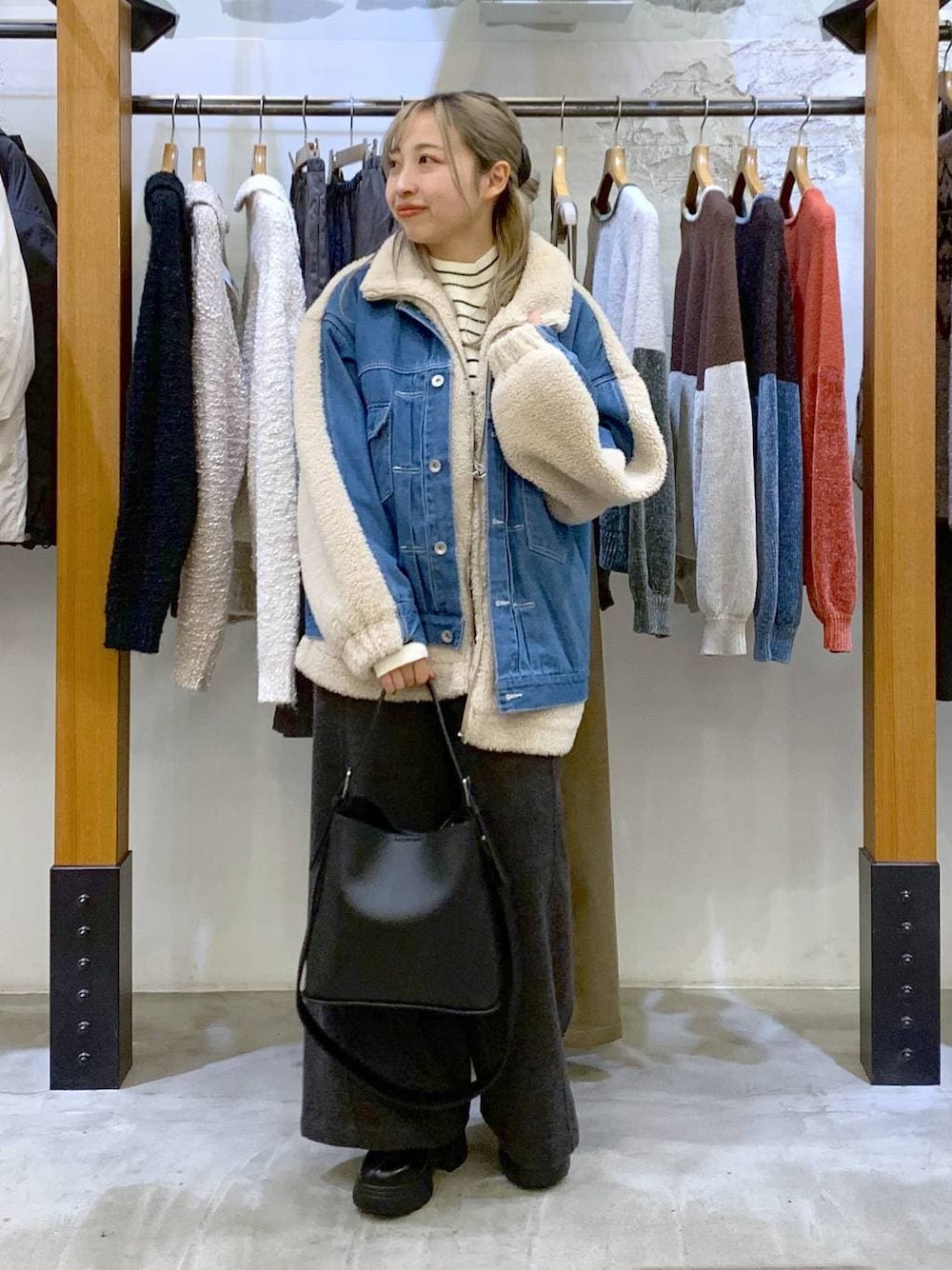 グレー系のその他パンツ、ホワイト系のニット/セーター、ブラック系のブーツを着用したレディースの秋コーディネートの1枚目の写真