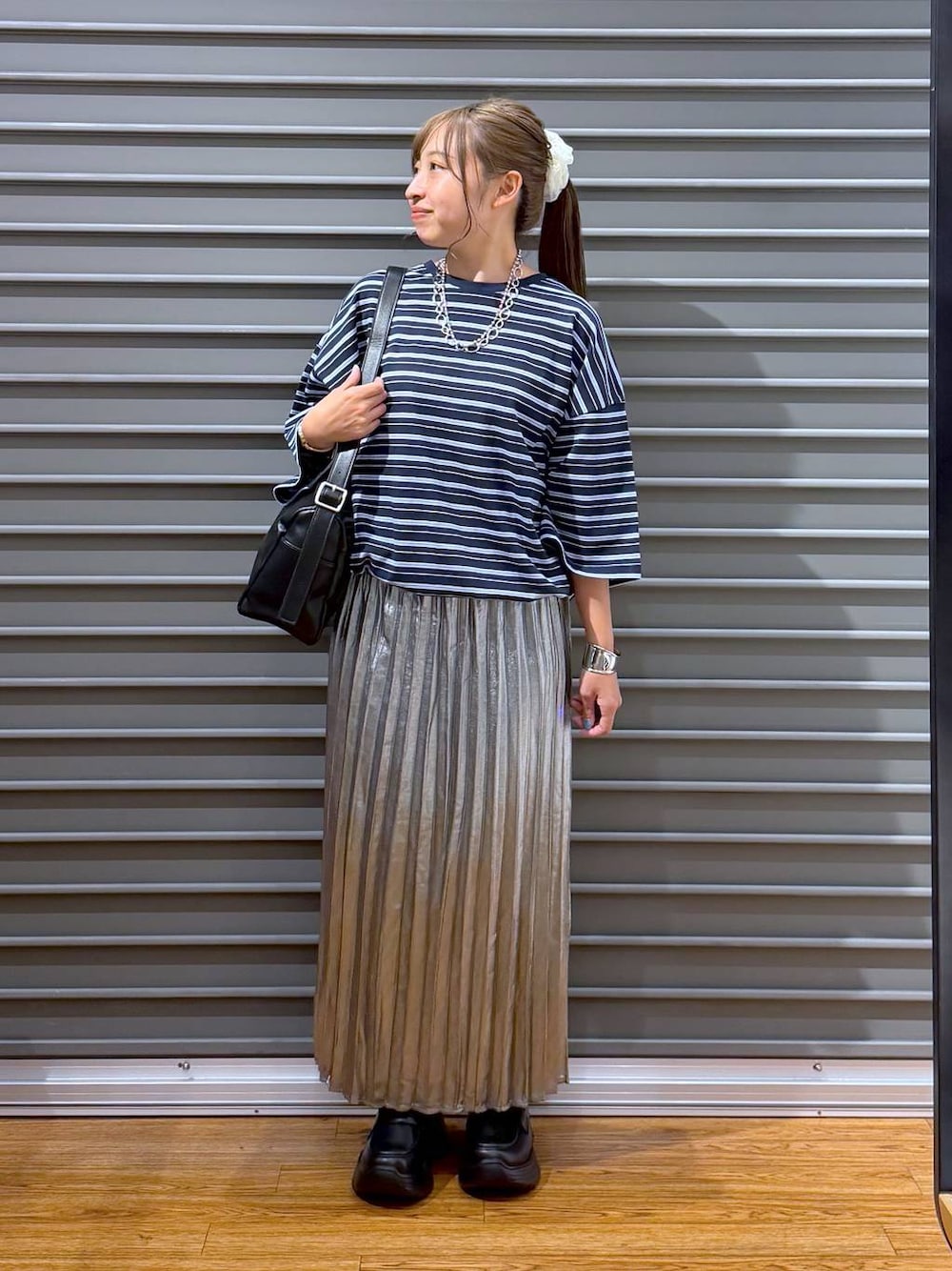 ブラック系のローファー、シルバー系のスカート、ブルー系のTシャツ/カットソーを着用したレディースの夏コーディネートの1枚目の写真