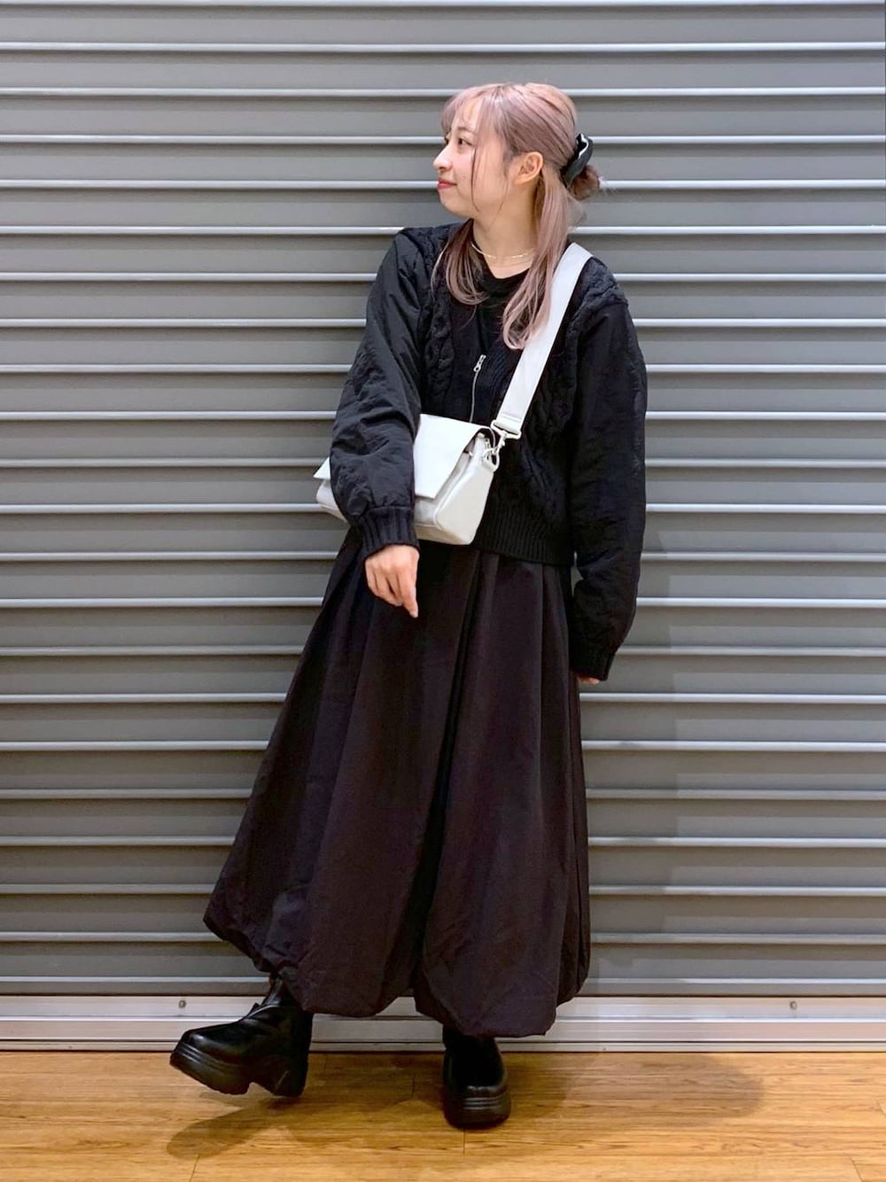 グレー系のショルダーバッグ、ブラック系のカーディガン/ボレロ、ブラック系のブーツを着用したレディースの冬コーディネートの1枚目の写真