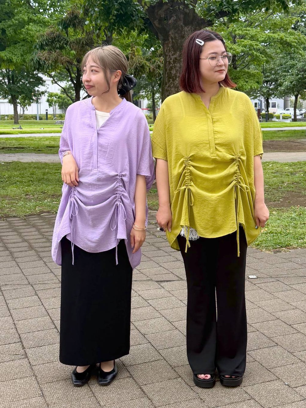 ブラック系のスカート、ブラック系のパンプス、ホワイト系のタンクトップを着用したレディースの春コーディネートの1枚目の写真