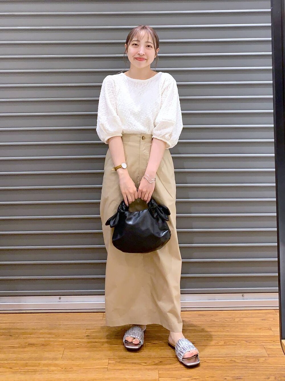 ホワイト系のTシャツ/カットソー、ベージュ系のスカート、ブラック系のショルダーバッグを着用したレディースの夏コーディネートの1枚目の写真