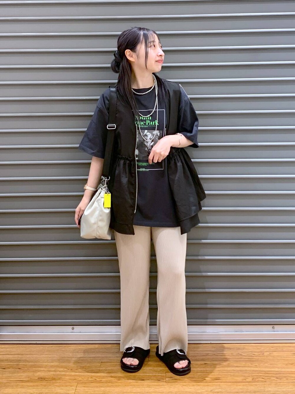 ブラック系のベスト、ベージュ系のその他パンツ、ブラック系のサンダルを着用したレディースの夏コーディネートの1枚目の写真