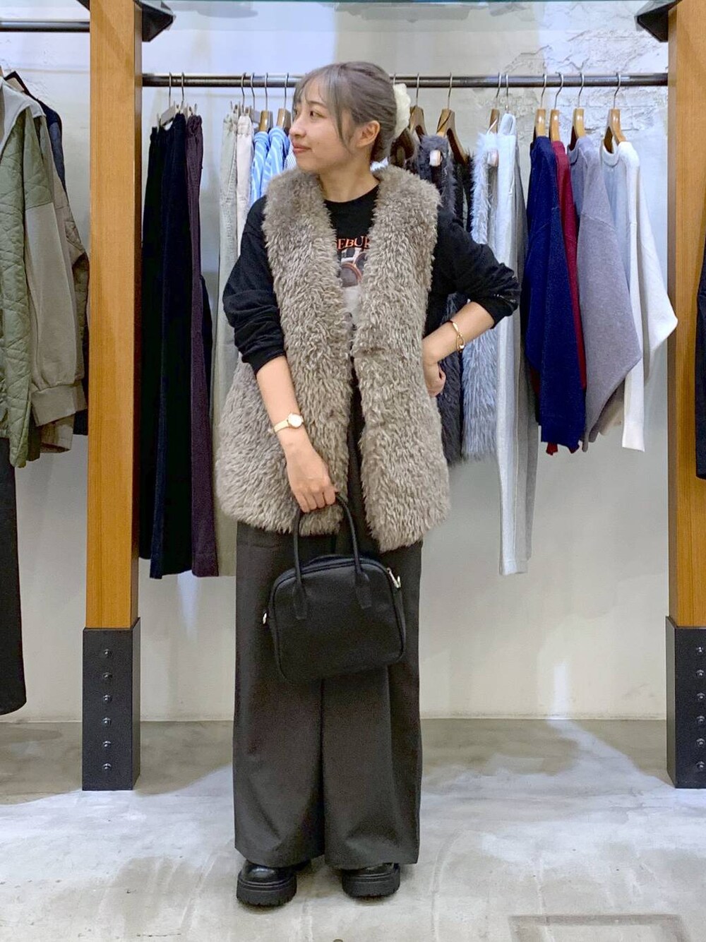 グレー系のその他パンツ、ブラック系のボストンバッグ、グレー系のベストを着用したレディースの秋コーディネートの1枚目の写真