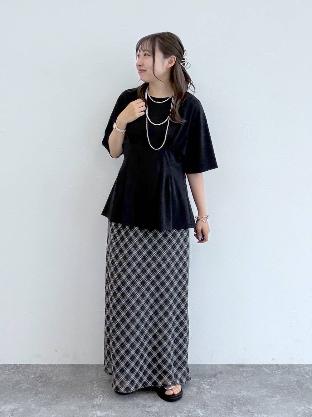 ブラック系のサンダル、ブラック系のスカート、ブラック系のTシャツ/カットソーを着用したレディースの夏コーディネートの1枚目の写真