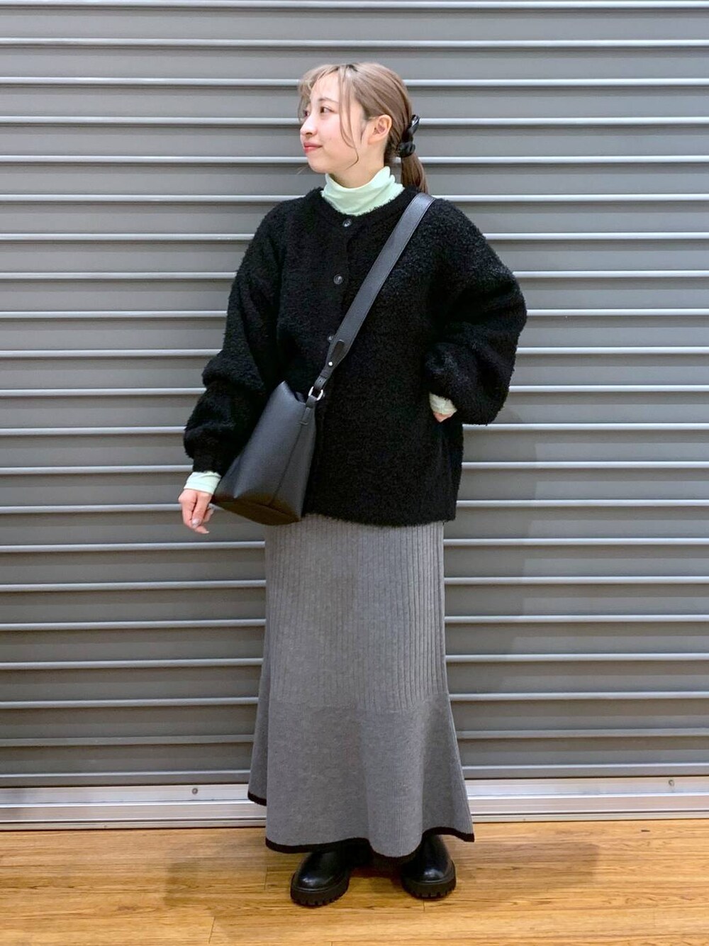 ブラック系のブーツ、ブラック系のワンピース、グリーン系のTシャツ/カットソーを着用したレディースの冬コーディネートの1枚目の写真