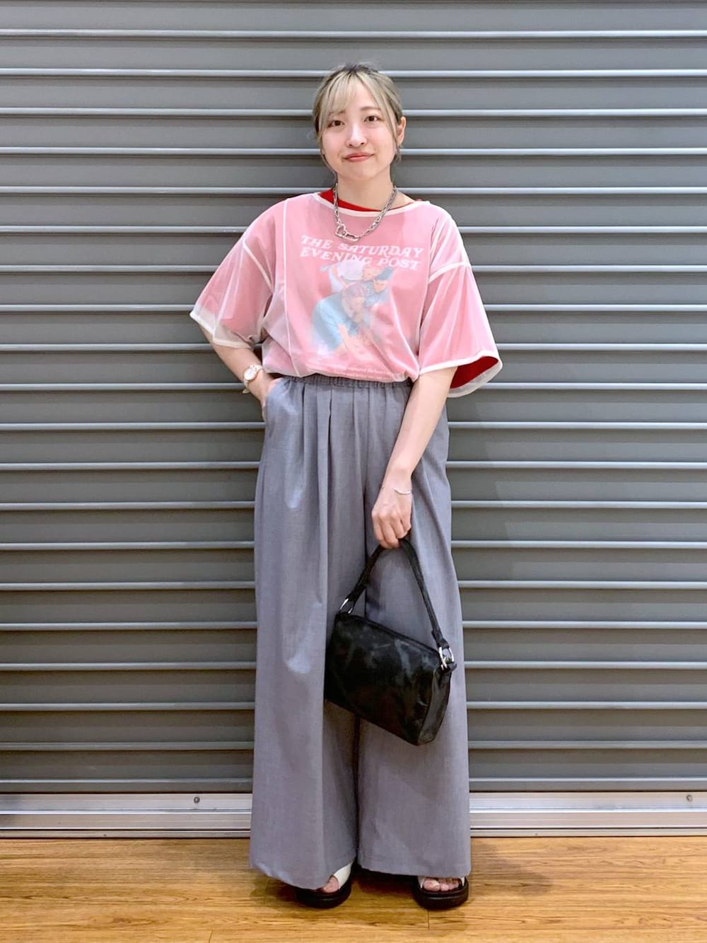 ホワイト系のサンダル、グレー系のその他パンツ、ブラック系のハンドバッグを着用したレディースの夏コーディネートの1枚目の写真