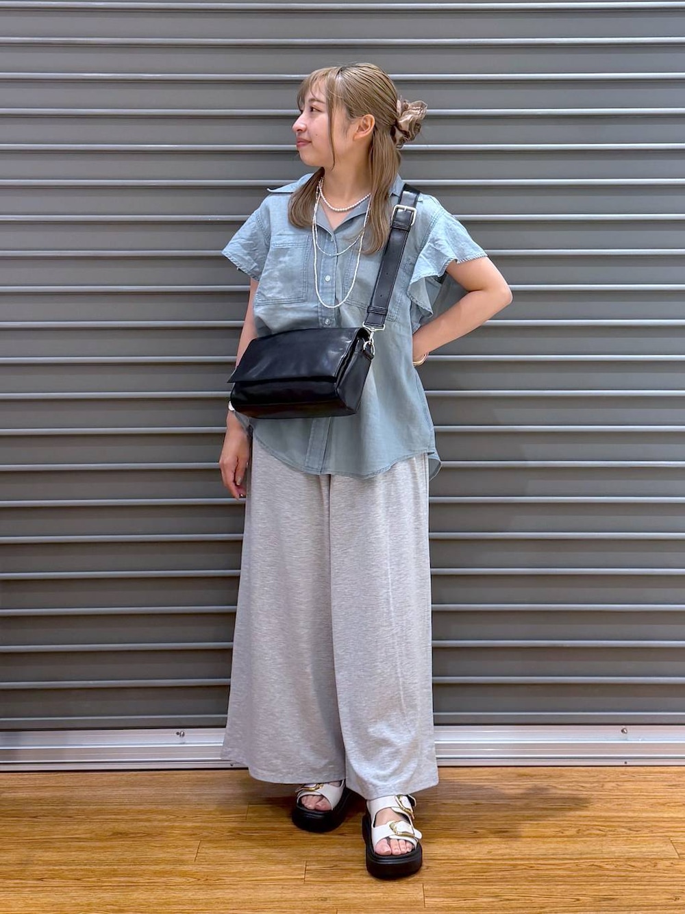 グレー系のその他パンツ、ブラック系のショルダーバッグ、ホワイト系のサンダルを着用したレディースの夏コーディネートの1枚目の写真