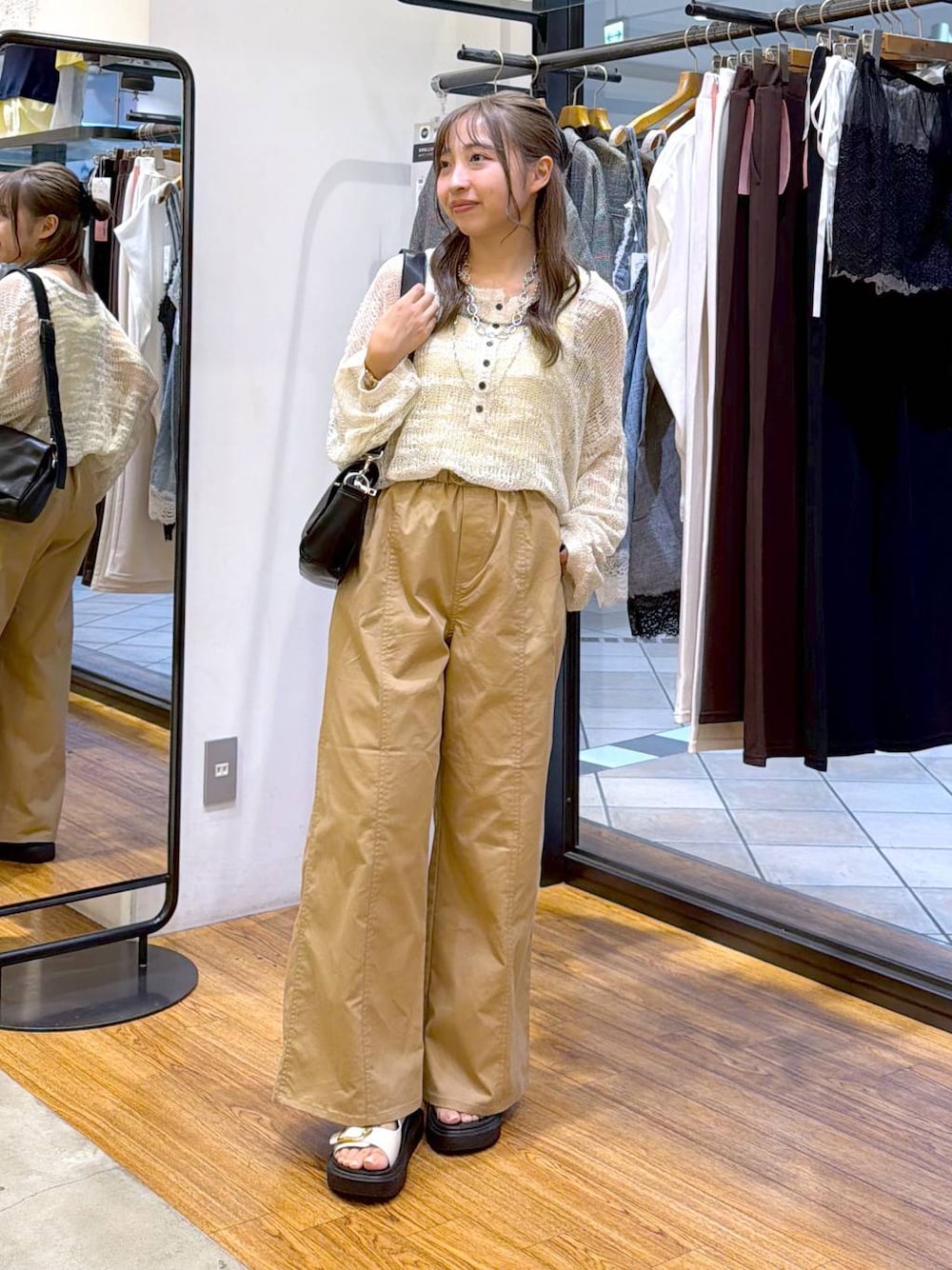 ベージュ系のその他パンツ、ホワイト系のニット/セーター、ブラック系のショルダーバッグを着用したレディースの秋コーディネートの1枚目の写真