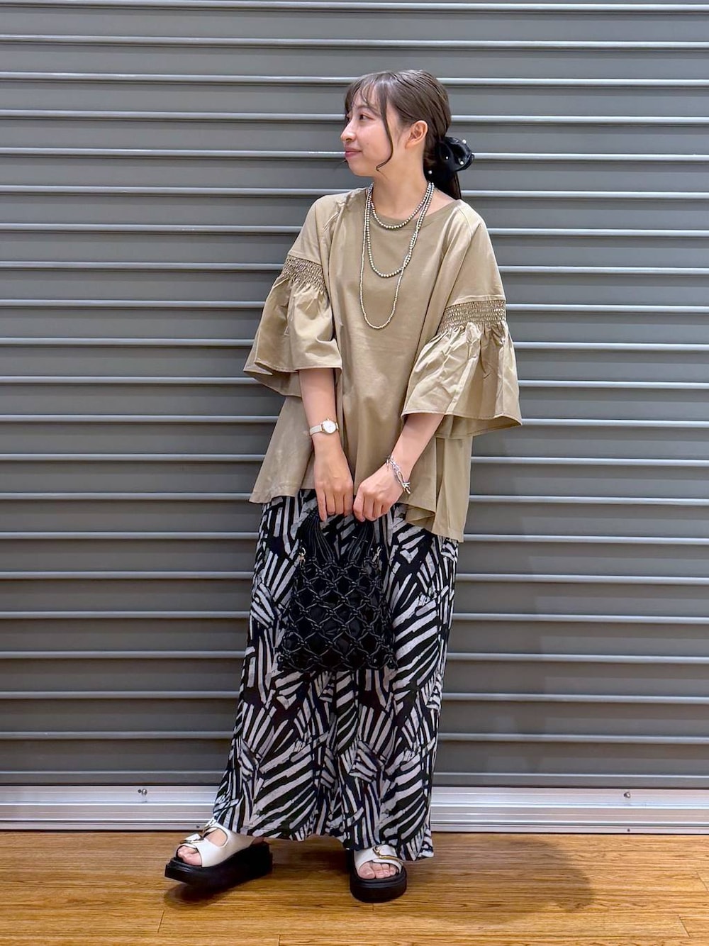 ベージュ系のTシャツ/カットソー、ブラック系のその他パンツ、ホワイト系のサンダルを着用したレディースの夏コーディネートの1枚目の写真