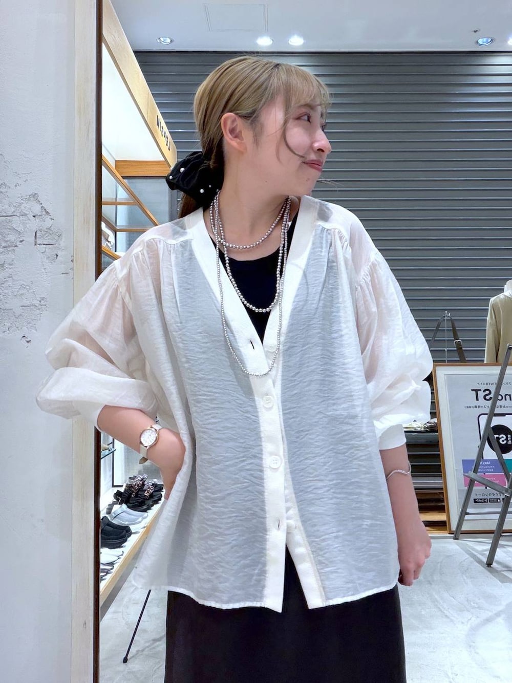 ベージュ系のシャツ/ブラウス、ブラック系のスカート、ブラック系のパンプスを着用したレディースの春コーディネートの1枚目の写真
