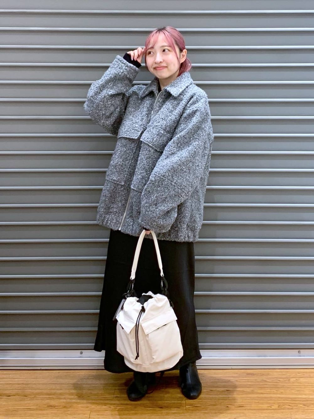 ホワイト系のショルダーバッグ、ブラック系のスカート、ブラック系のブーツを着用したレディースの秋コーディネートの1枚目の写真