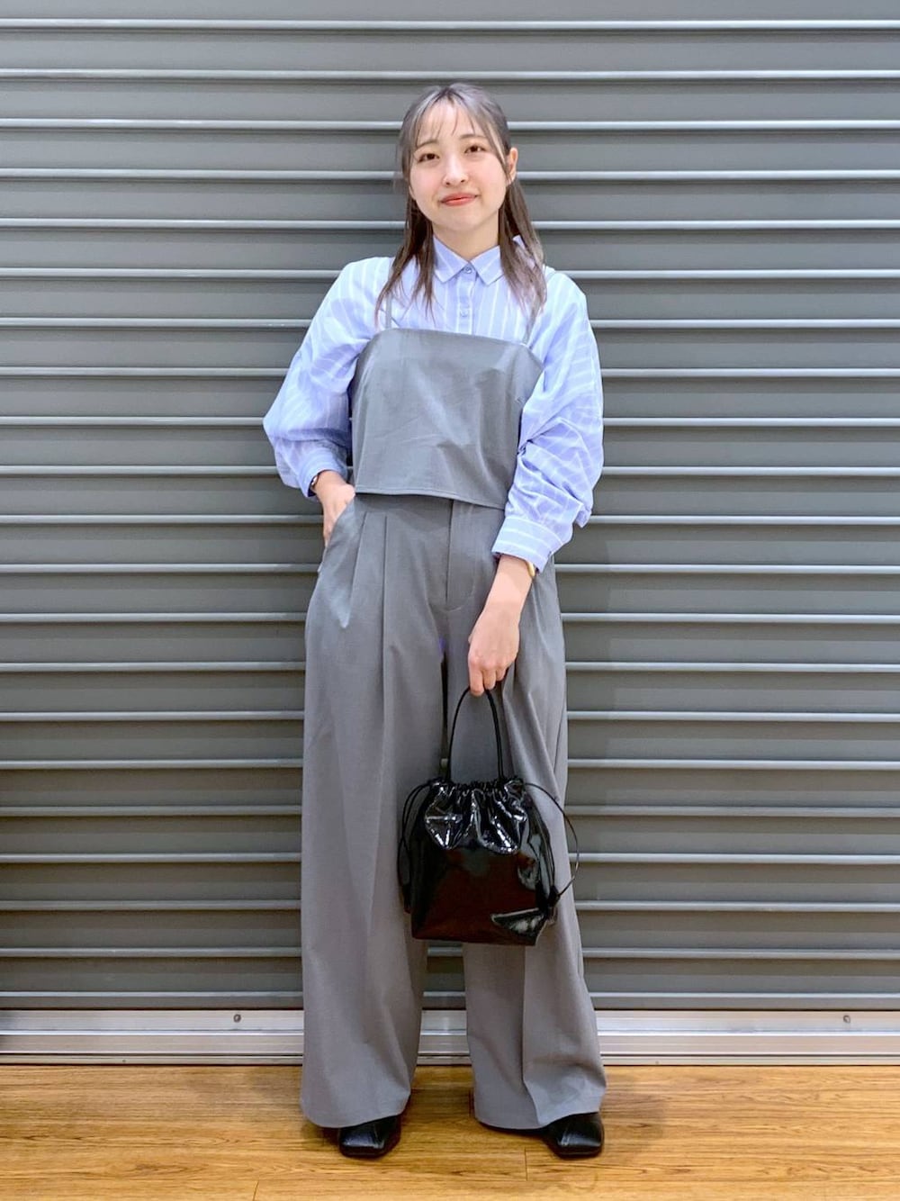 ブルー系のシャツ/ブラウス、グレー系のその他パンツ、ブラック系のパンプスを着用したレディースの春コーディネートの1枚目の写真