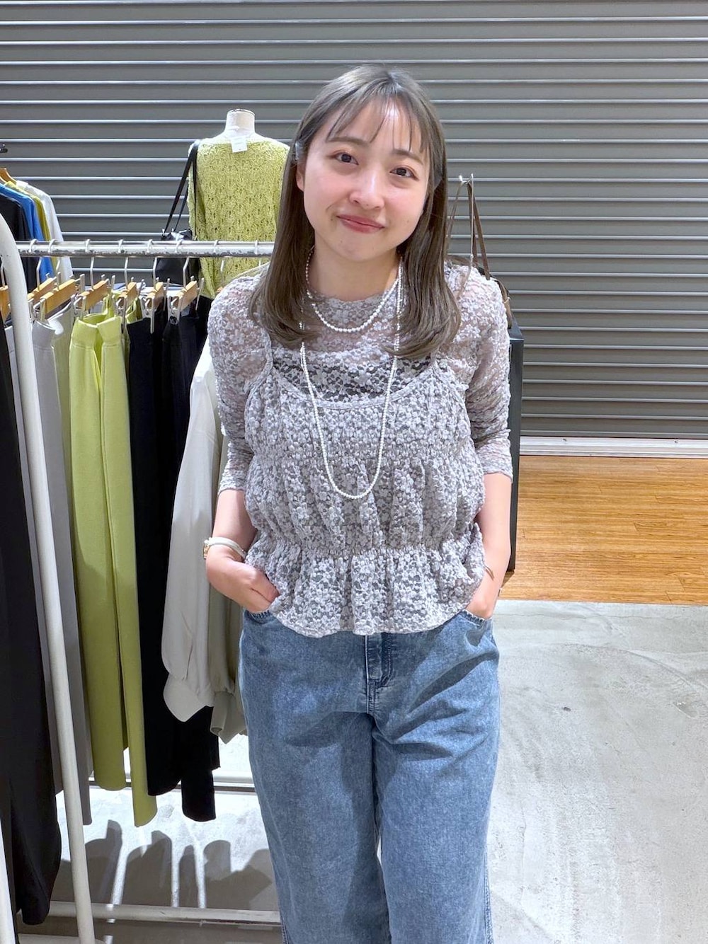 ブルー系のデニムパンツ、グレー系のTシャツ/カットソー、シルバー系のネックレスを着用したレディースの春コーディネートの1枚目の写真