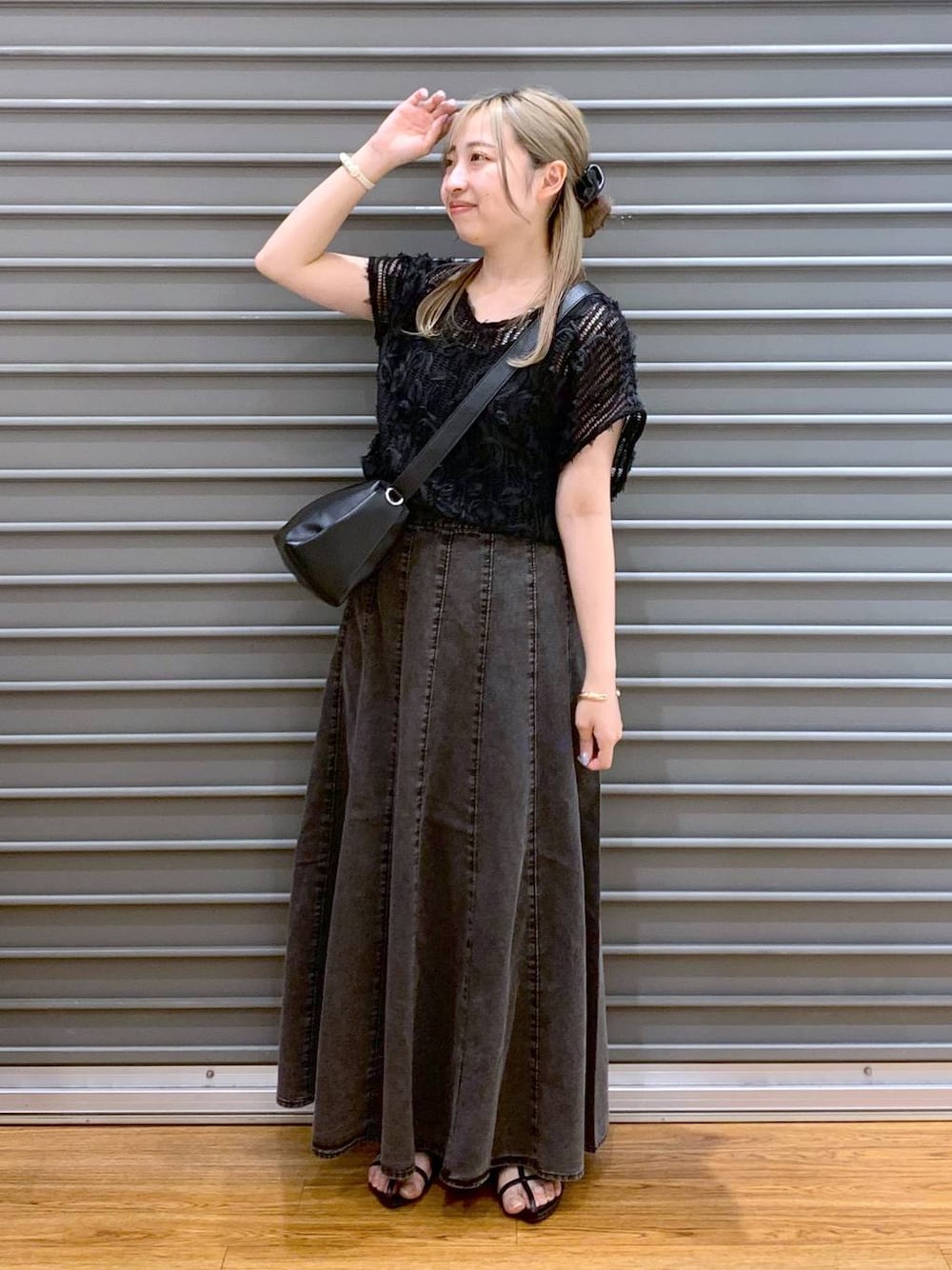 ブラック系のショルダーバッグ、グレー系のスカート、ブラック系のサンダルを着用したレディースの夏コーディネートの1枚目の写真
