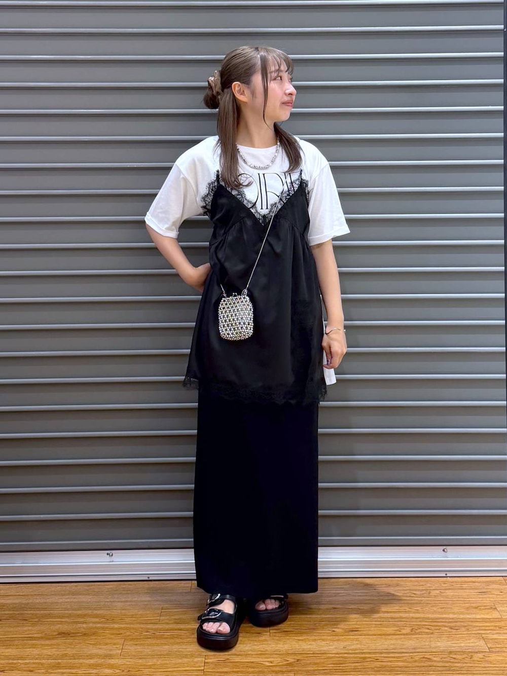 ブラック系のスカート、ブラック系のサンダル、ホワイト系のTシャツ/カットソーを着用したレディースの夏コーディネートの1枚目の写真