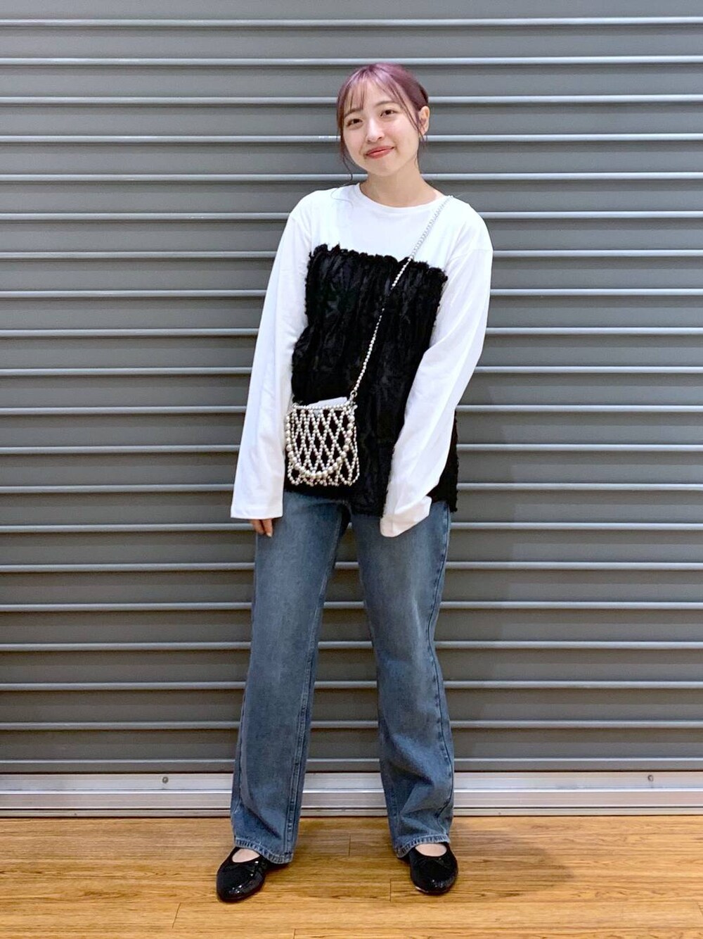 シルバー系のショルダーバッグ、ブルー系のデニムパンツ、ブラック系のバレエシューズを着用したレディースの秋コーディネートの1枚目の写真