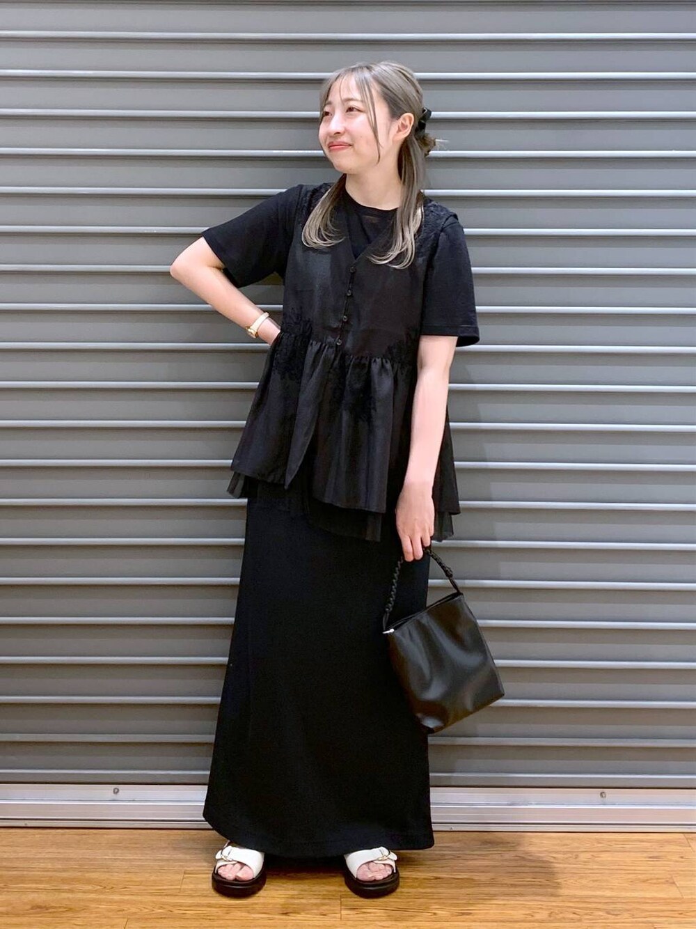 ホワイト系のサンダル、ブラック系のショルダーバッグ、ブラック系のシャツ/ブラウスを着用したレディースの夏コーディネートの1枚目の写真