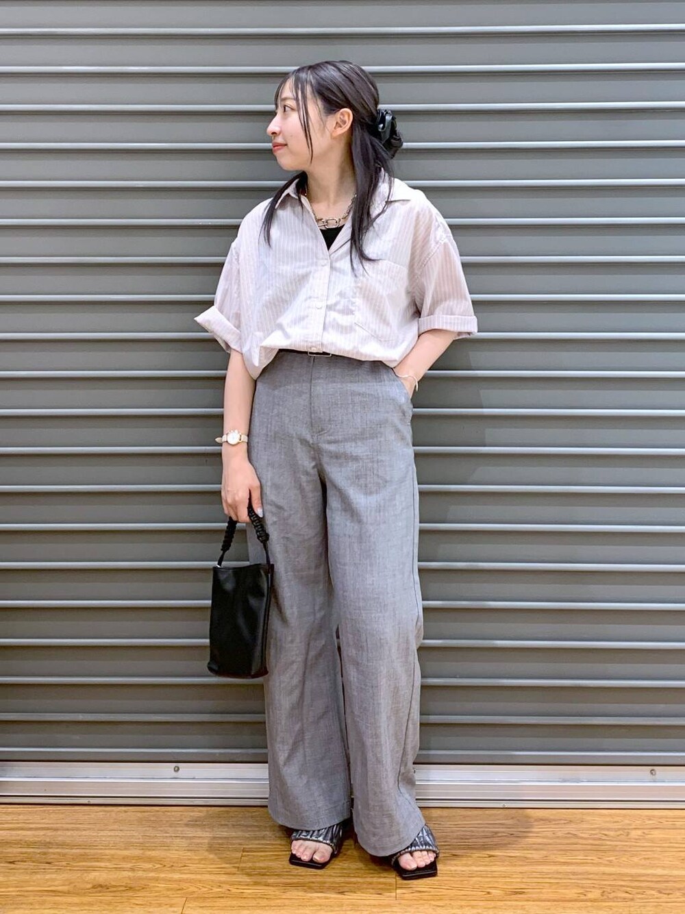 ピンク系のシャツ/ブラウス、グレー系のその他パンツ、ブラック系のショルダーバッグを着用したレディースの夏コーディネートの1枚目の写真