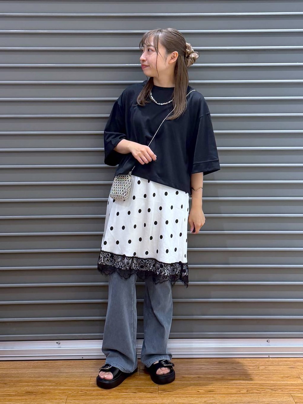 ブラック系のサンダル、ブラック系のTシャツ/カットソー、ブルー系のデニムパンツを着用したレディースの夏コーディネートの1枚目の写真