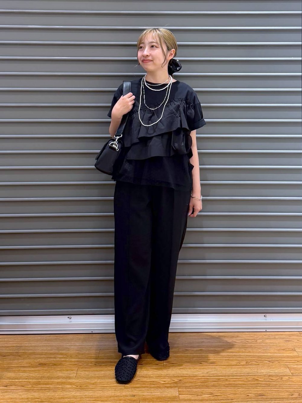 ブラック系のショルダーバッグ、ブラック系のその他パンツ、ブラック系のパンプスを着用したレディースの春コーディネートの1枚目の写真
