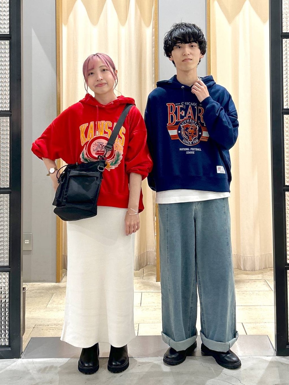 ブラック系のショルダーバッグ、ブルー系のデニムパンツ、ブラック系のブーツを着用したレディースの秋コーディネートの1枚目の写真