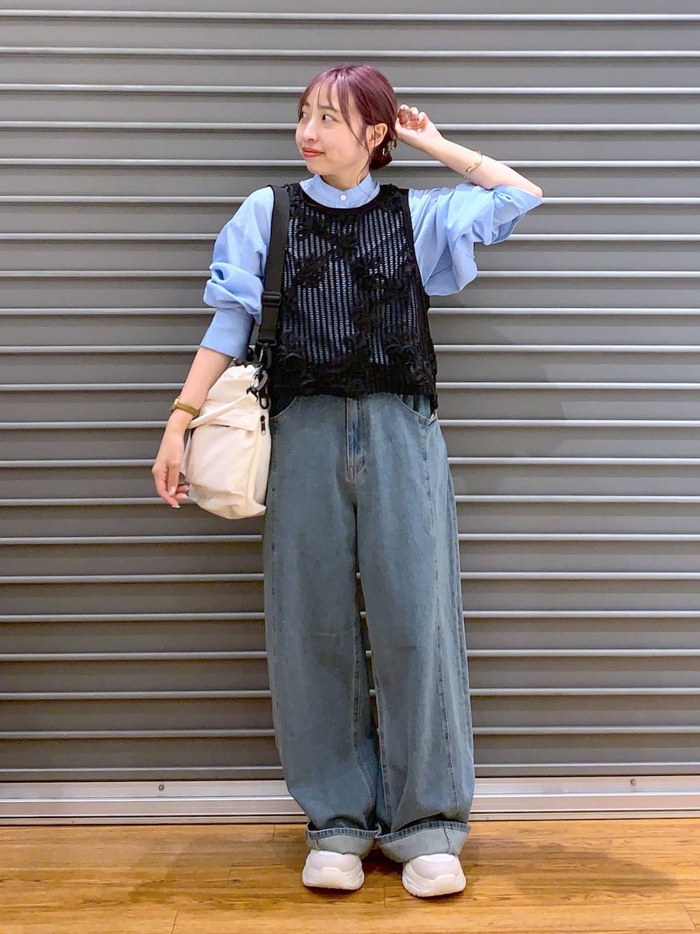 ホワイト系のショルダーバッグ、ブルー系のデニムパンツ、ホワイト系のスニーカーを着用したレディースの秋コーディネートの1枚目の写真