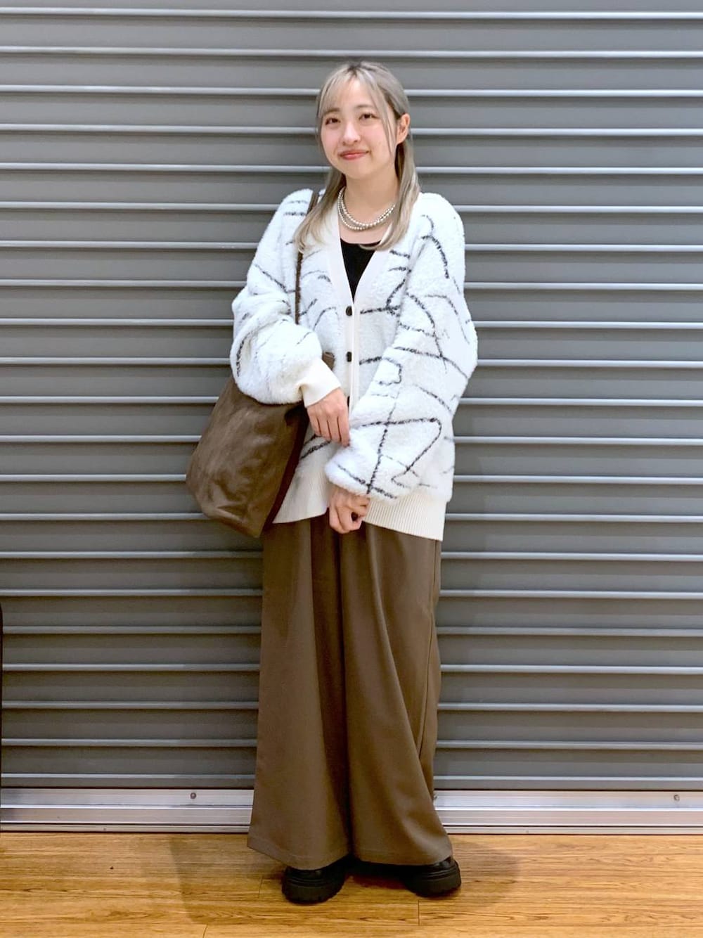 ブラウン系のその他パンツ、ホワイト系のカーディガン/ボレロ、ブラック系のブーツを着用したレディースの秋コーディネートの1枚目の写真