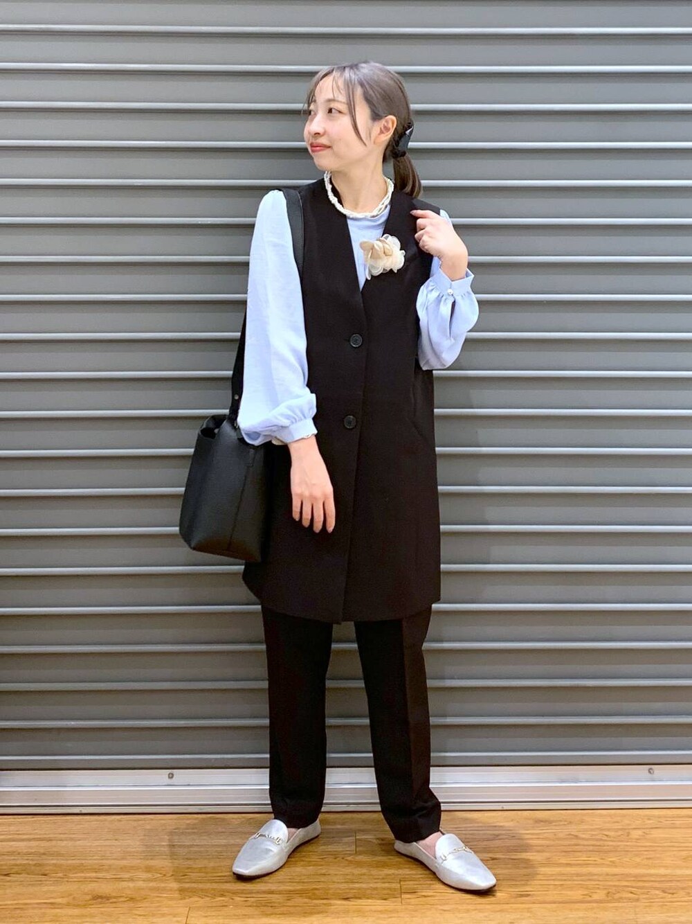 ブラック系のスーツパンツ、ブルー系のシャツ/ブラウス、ブラック系のスーツベストを着用したレディースの冬コーディネートの1枚目の写真