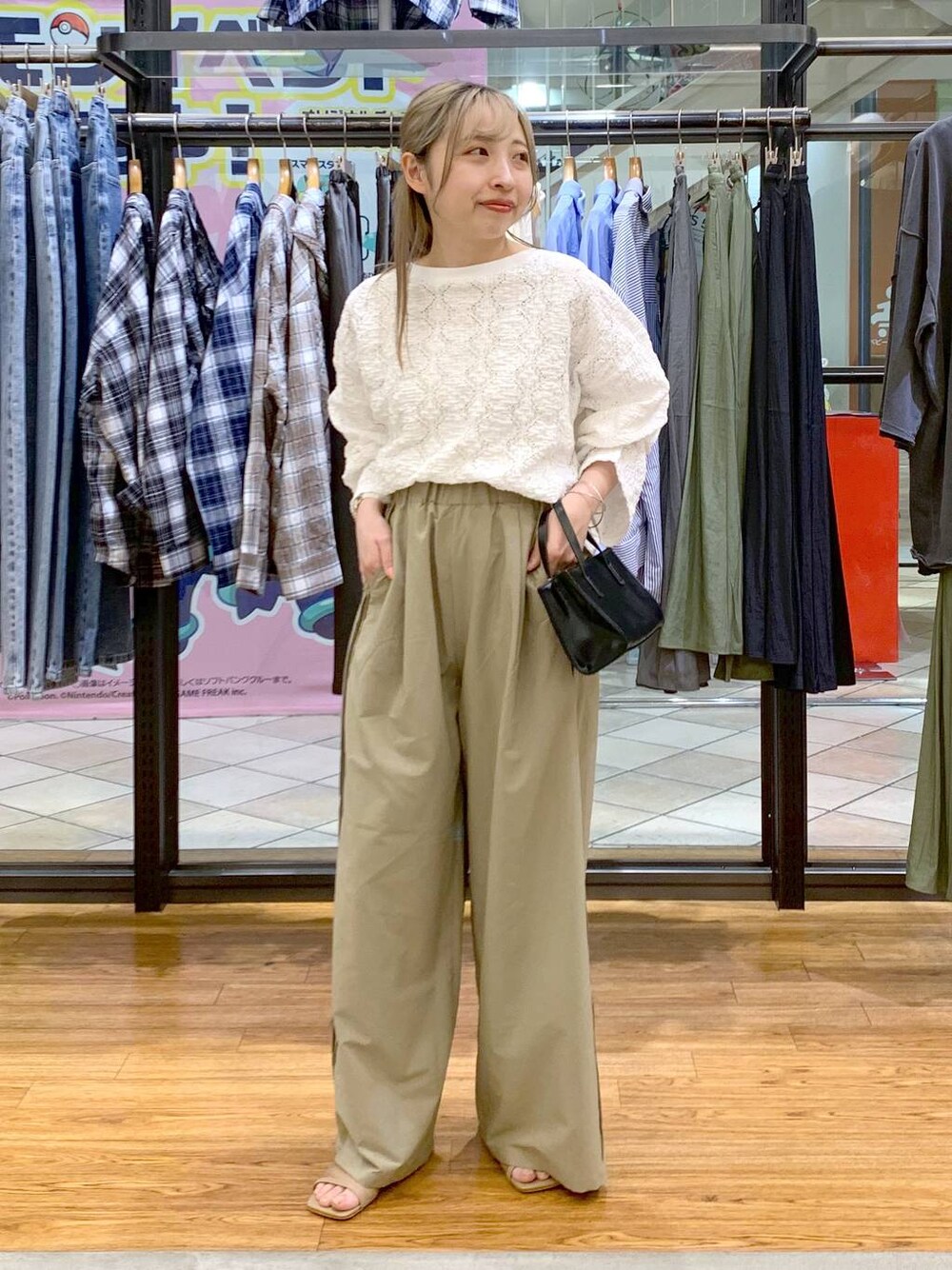 ブラック系のショルダーバッグ、ベージュ系のその他パンツ、ホワイト系のTシャツ/カットソーを着用したレディースの春コーディネートの1枚目の写真