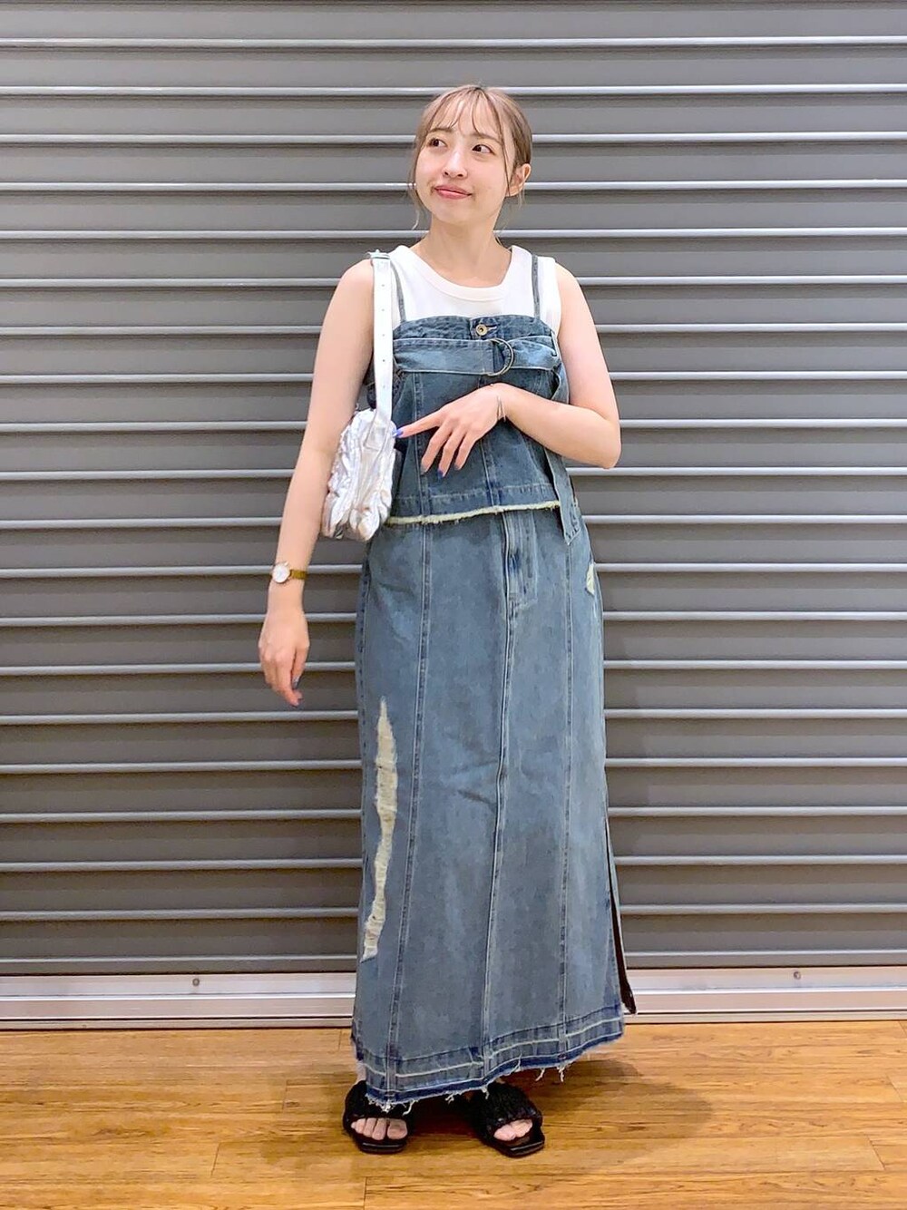 シルバー系のショルダーバッグ、ブラック系のサンダル、ホワイト系のタンクトップを着用したレディースの夏コーディネートの1枚目の写真