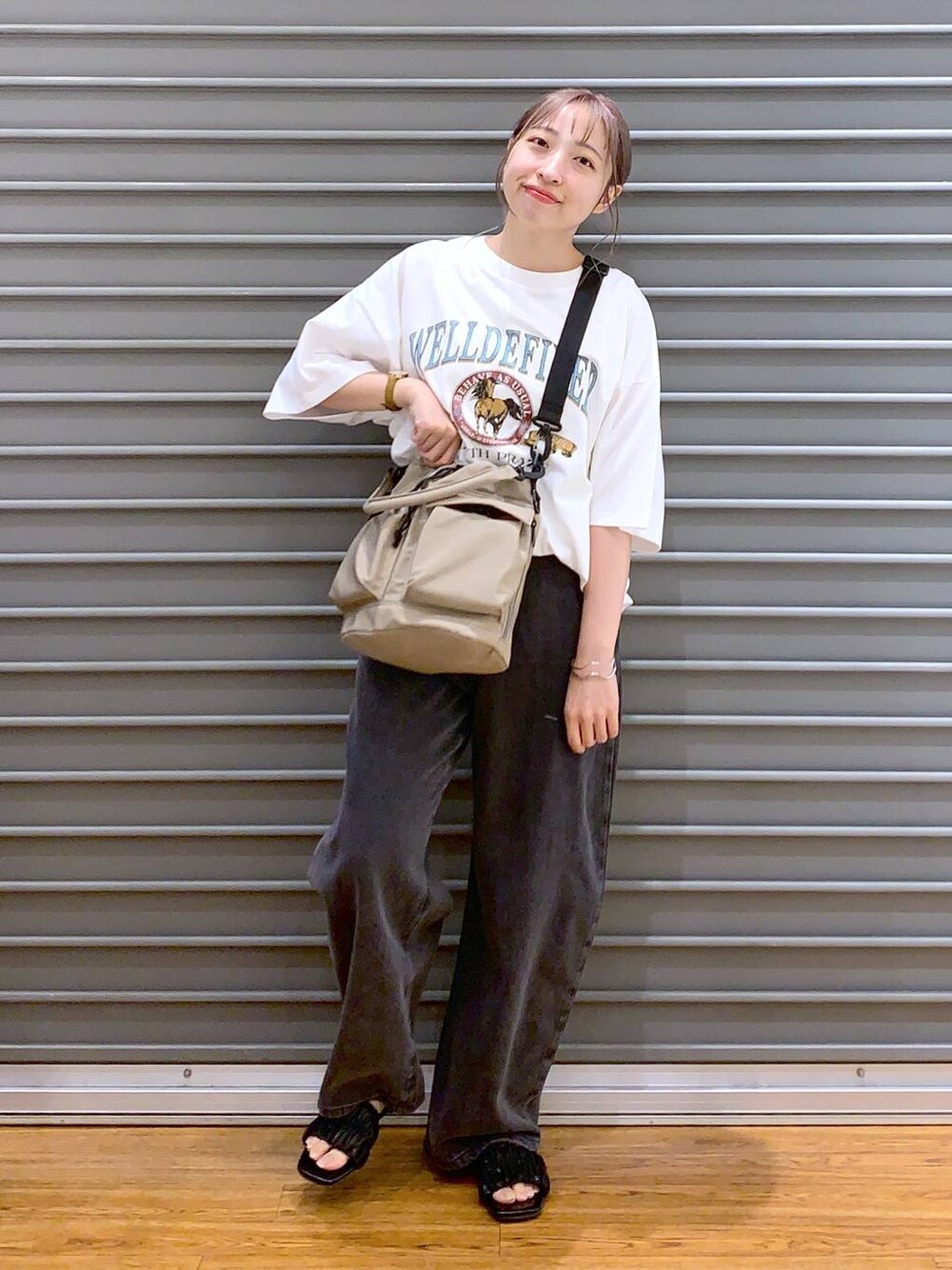 ホワイト系のTシャツ/カットソー、ブラック系のデニムパンツ、ベージュ系のショルダーバッグを着用したレディースの夏コーディネートの1枚目の写真