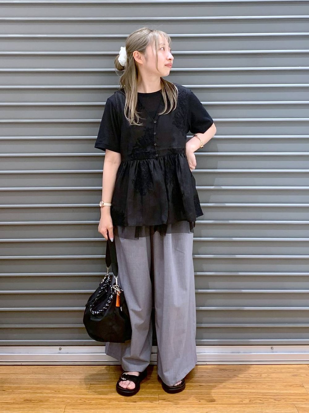 ブラック系のサンダル、グレー系のその他パンツ、ブラック系のショルダーバッグを着用したレディースの夏コーディネートの1枚目の写真