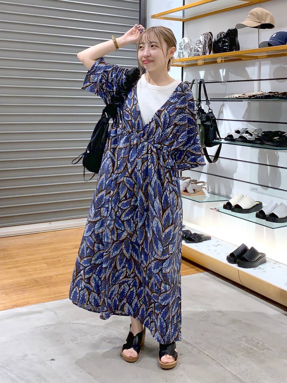 ブラック系のショルダーバッグ、ブラック系のサンダル、ホワイト系のタンクトップを着用したレディースの夏コーディネートの1枚目の写真