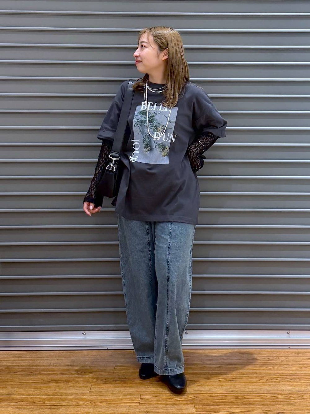 ブラック系のショルダーバッグ、グレー系のTシャツ/カットソー、ブラック系のパンプスを着用したレディースの春コーディネートの1枚目の写真