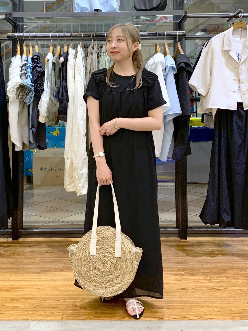 ホワイト系のサンダル、ホワイト系のショルダーバッグ、ブラック系のジャンパースカートを着用したレディースの夏コーディネートの1枚目の写真