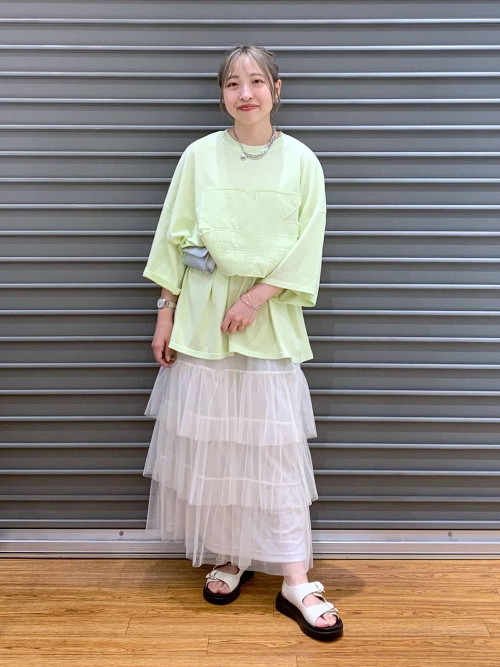 ホワイト系のサンダル、シルバー系のボディバッグ/ウエストポーチ、ホワイト系のスカートを着用したレディースの春コーディネートの1枚目の写真