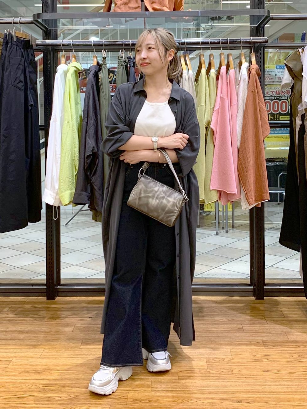 グレー系のワンピース、ホワイト系のタンクトップ、ブルー系のデニムパンツを着用したレディースの春コーディネートの1枚目の写真