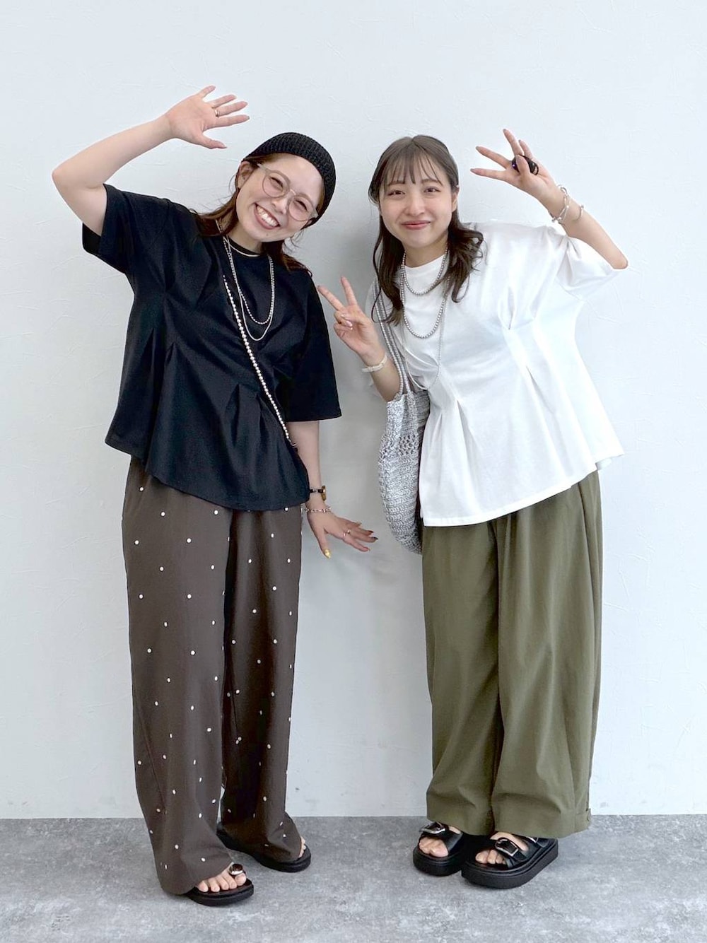 ブラック系のサンダル、グリーン系のその他パンツ、シルバー系のショルダーバッグを着用したレディースの夏コーディネートの1枚目の写真