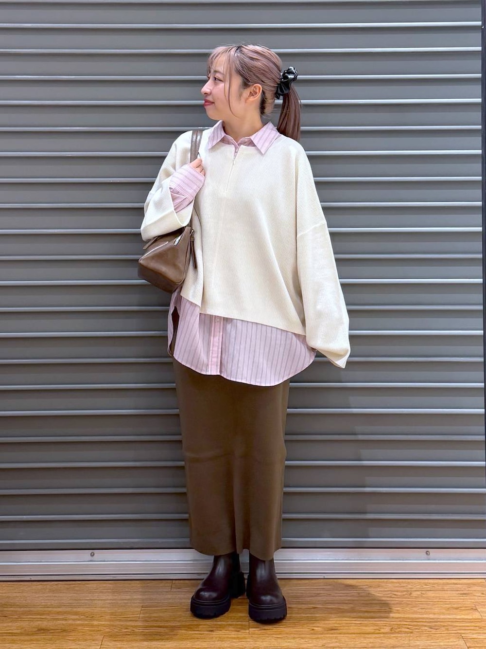 ブラウン系のスカート、ホワイト系のニット/セーター、ブラウン系のブーツを着用したレディースの冬コーディネートの1枚目の写真